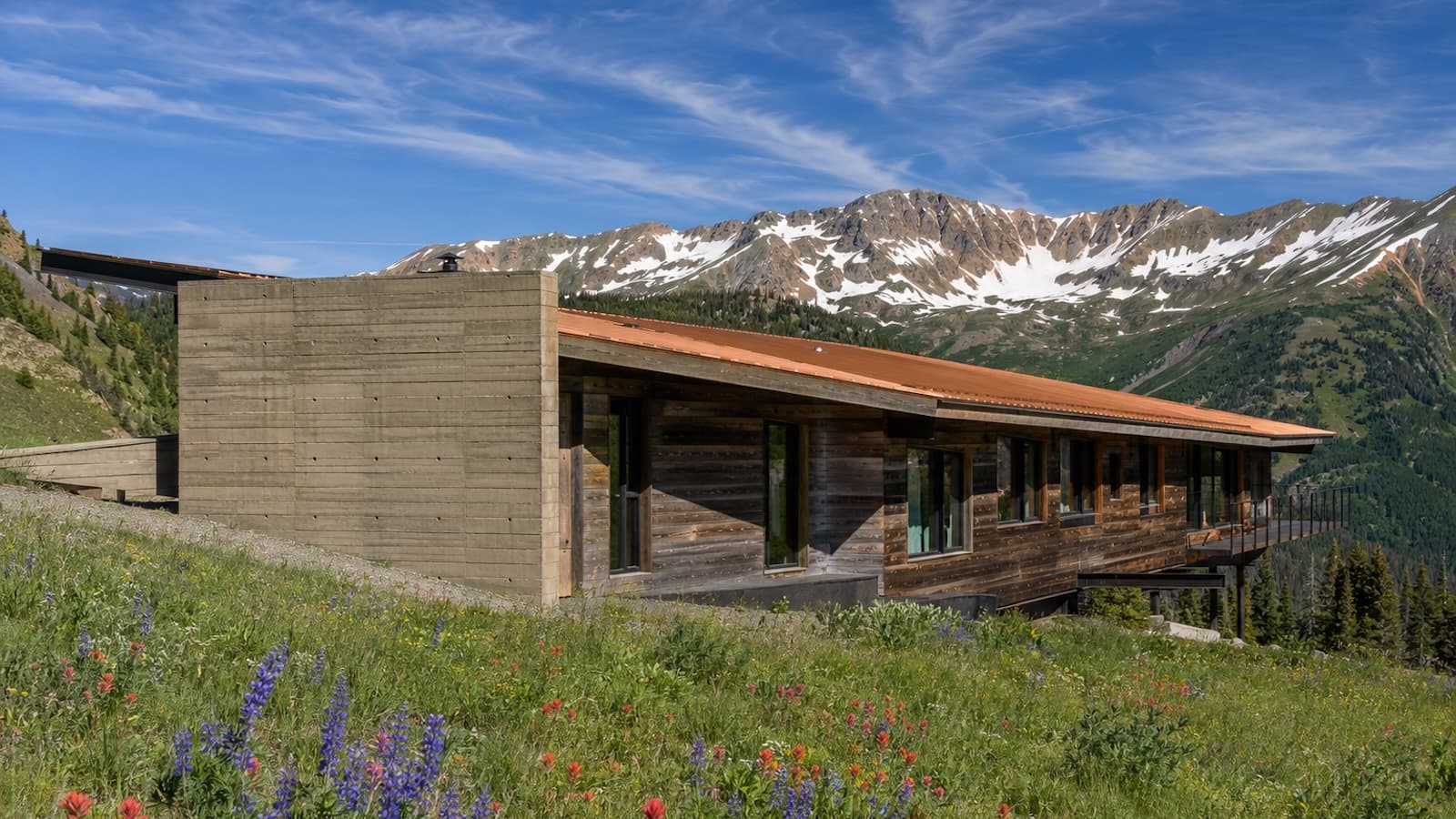 Ridgeline House — low-slung estate of board-formed concrete and reclaimed cedar hugging a snowy ridgeline